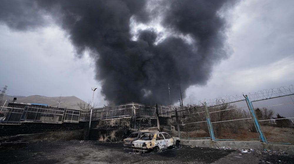 A thick plume of smoke rises from an oil storage facility hit by a U.S.-Israeli strike late Saturday in Tehran, Iran, Sunday, March 8, 2026. (AP Photo/Vahid Salemi)