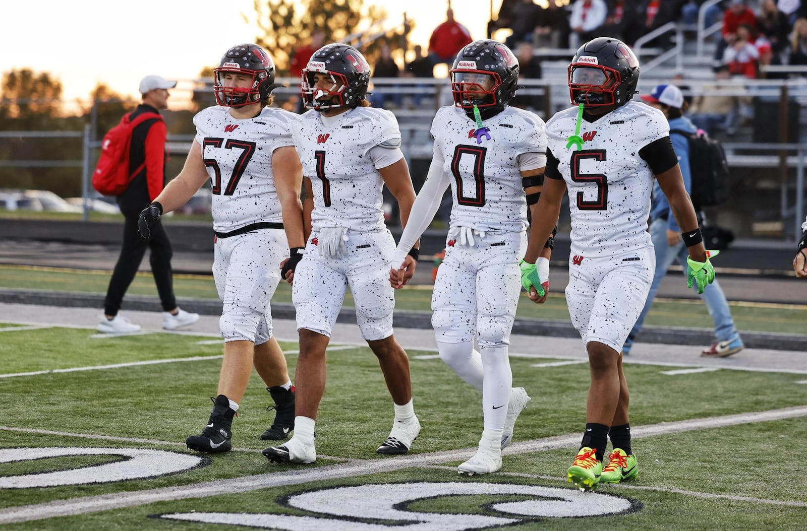 Lakota West captains make their way out gor the coin flip before their football game against Lakota East Friday, Oct. 24, 2025 at Lakota East High School in Liberty Township. East won 42-28. NICK GRAHAM/STAFF