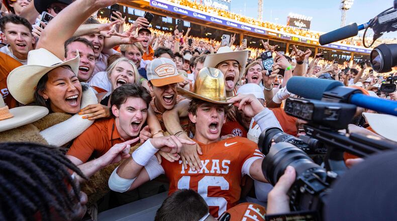 Texas quarterback Arch Manning, center, celebrates with fans after defeating Oklahoma in an NCAA college football game Saturday, Oct. 11, 2025, in Dallas. (AP Photo/Jeffrey McWhorter)