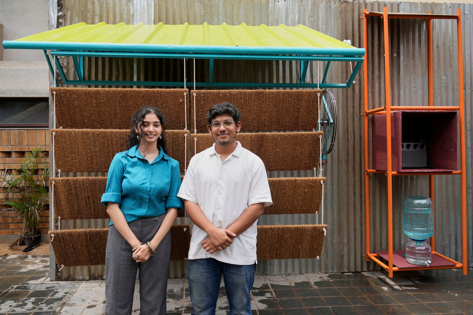 Ankritya Diggavi, left, and Sagar Kandal, architects behind the design of Neralu, an innovative portable heat shelter, pose in front of their installation at the Sweat and Concrete 2025 event in Bengaluru, India, Thursday, May 29, 2025. (AP Photo/Aijaz Rahi)