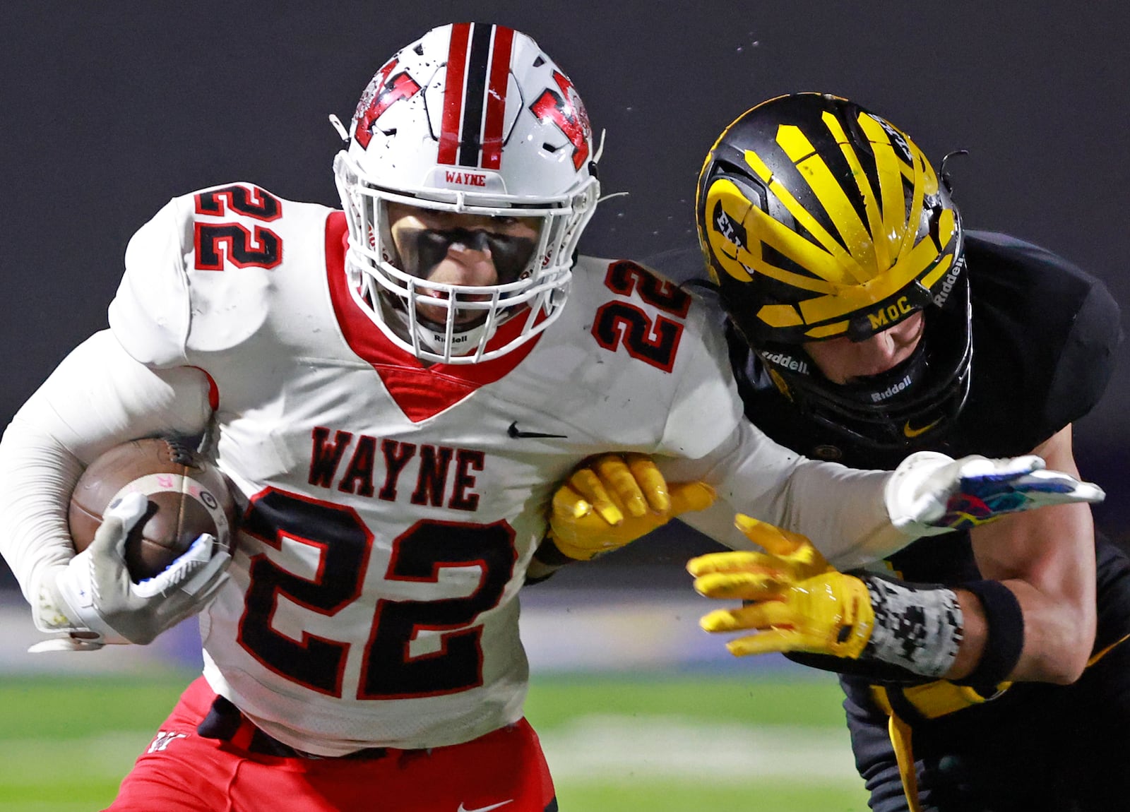 Wayne's Isaiah Thompson tries to avoid being tackled by Centerville's Andrew Erwin during Friday's regional championship game. BILL LACKEY/STAFF