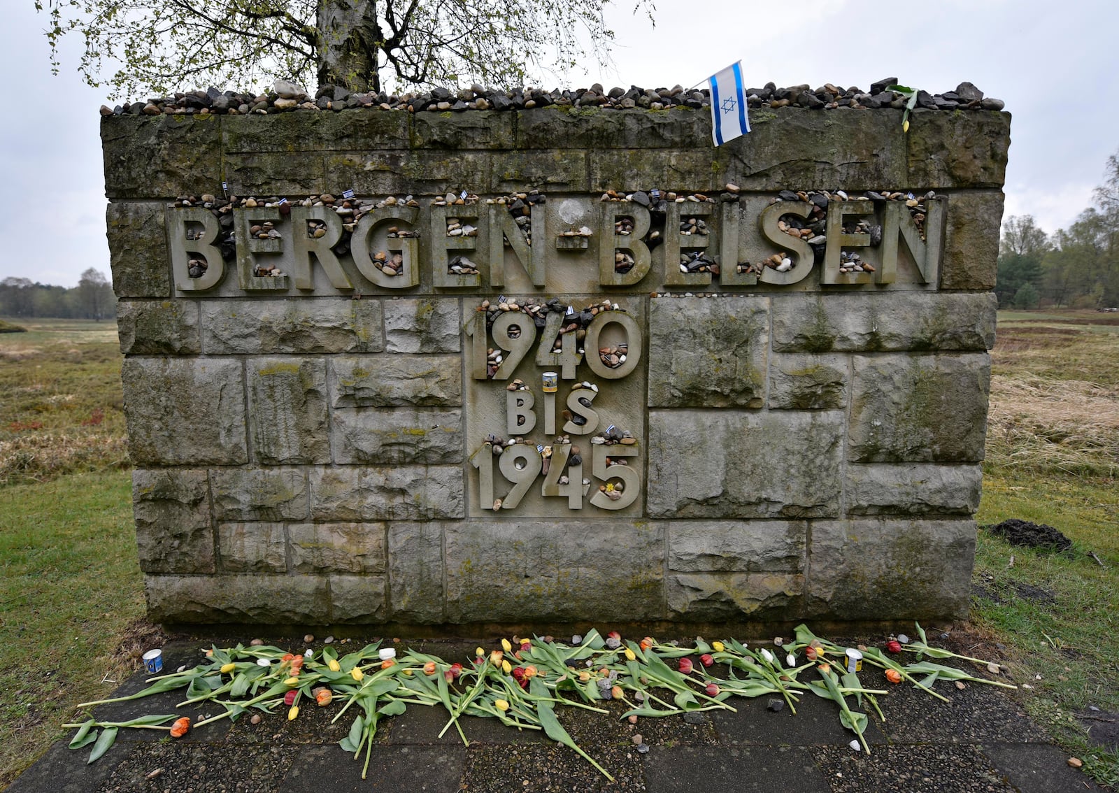 FILE — Flowers and stones are placed for the victims at a memorial stone at the Bergen-Belsen concentration camp in Bergen, northern Germany, April 26, 2015. (AP Photo/Martin Meissner, File)
