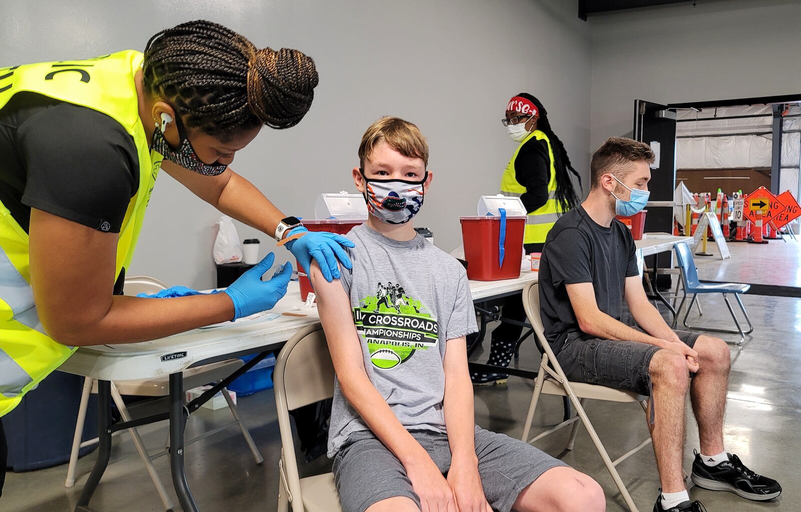 Chase Dwyer, 12, gets his COVID-19 vaccine administered by nurse Ronisha Reid as his brother, Brendan Dwyer, 17, waits for his turn Wednesday, June 9, 2021 at the Butler County Fairgrounds. The Butler County Health Department with help from other agencies continues their COVID-19 vaccination clinics with Walk-in Wednesdays at the Butler County Fairgrounds in Hamilton. The clinic runs from 9 a.m. until noon on Wednesdays. NICK GRAHAM / STAFF