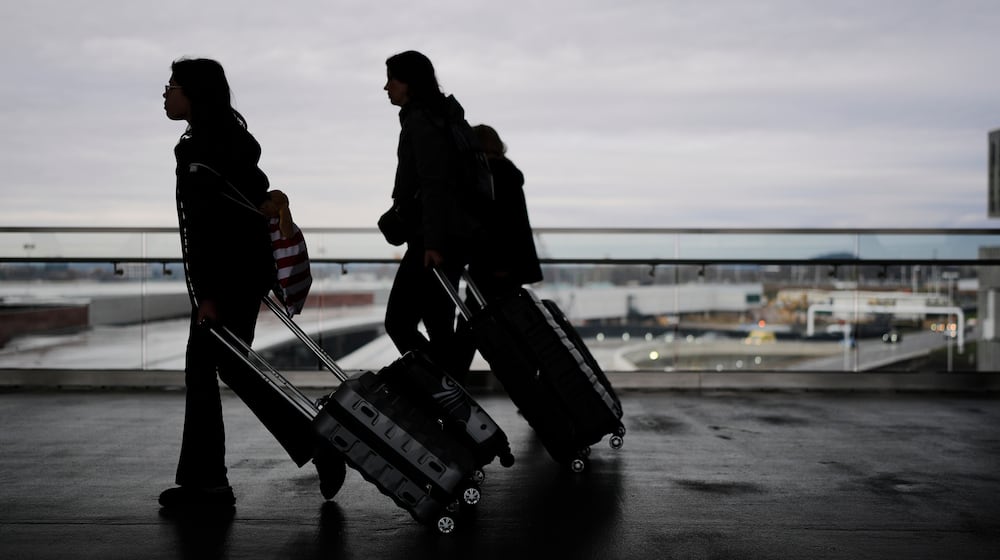 Travelers make their way through the Nashville International Airport, Tuesday, Nov. 25, 2025, in Nashville, Tenn. (AP Photo/George Walker IV)