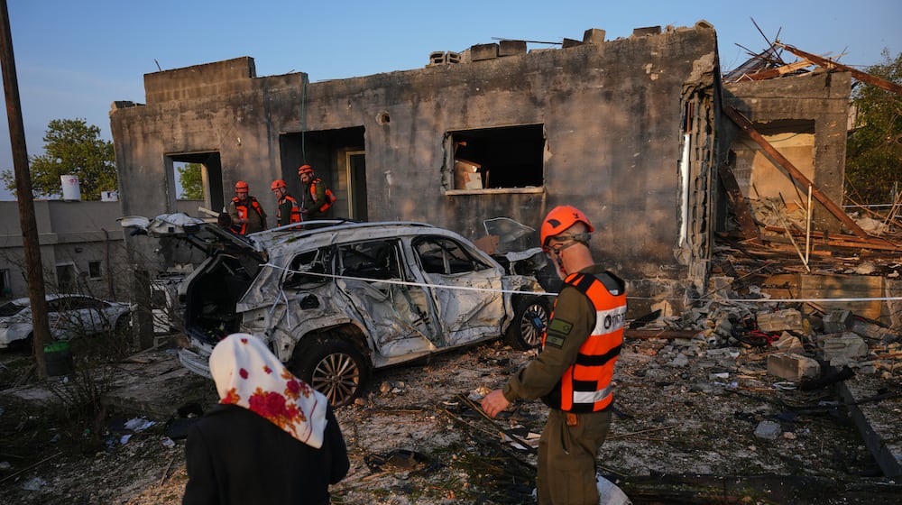 Residents and officers from Israel's Home Front Command inspect a house destroyed by an Iranian missile strike in Zarzir, northern Israel, Friday, March 13, 2026. (AP Photo/Ariel Schalit)