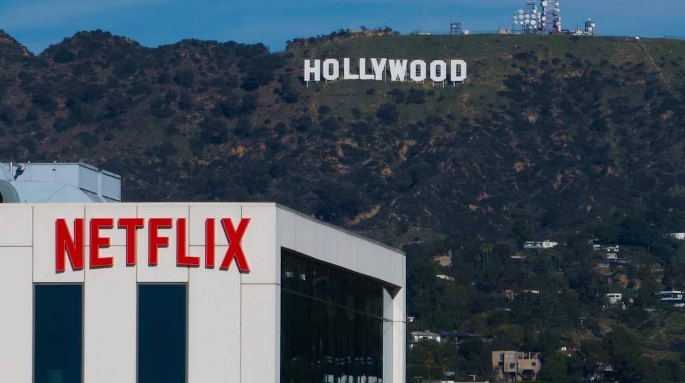 FILE - A Netflix sign is displayed atop a building in Los Angeles, on Dec. 18, 2025, with the Hollywood sign in the distance. (AP Photo/Jae C. Hong, File)