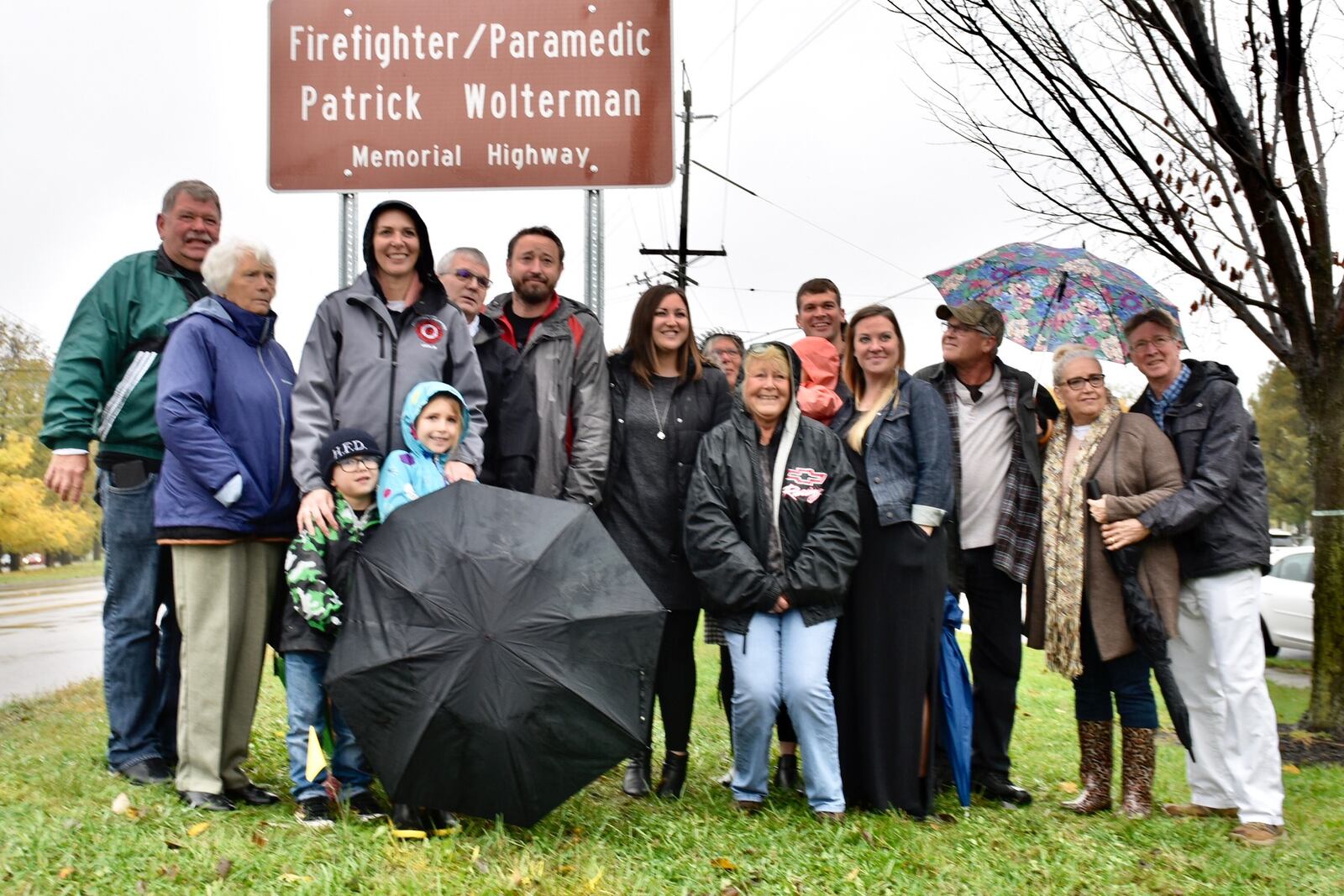 The family of fallen Hamilton firefighter/paramedic Patrick Wolterman stands in front of the sign that makes a stretch of Ohio 4 from North Fair Avenue to High Street in his honor.