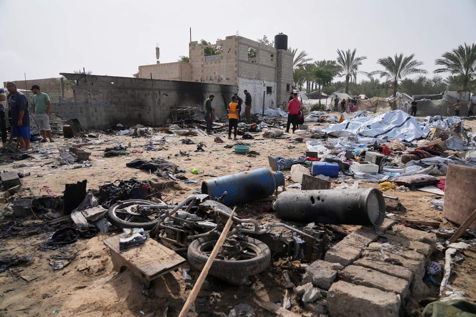Palestinians inspect the site destroyed by Israeli airstrikes in Khan Younis, Gaza Strip, Sunday, May 18, 2025. (AP Photo/Abdel Kareem Hana)