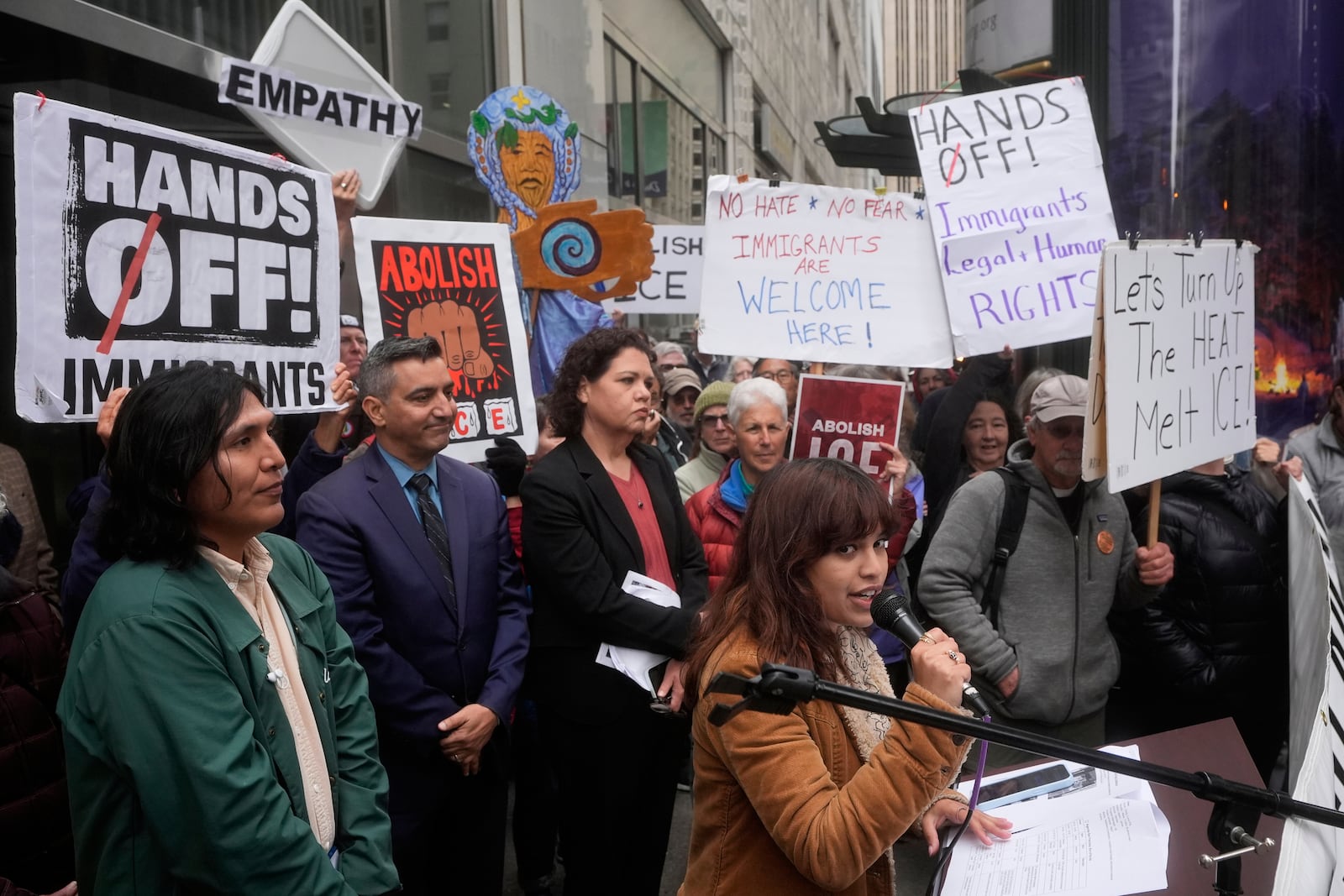 Sanika Mahajan, with Mission Action and San Francisco Rapid Response Network, bottom middle, speaks during a news conference and rally by immigrant justice organizations and advocates to protest ICE arrests in San Francisco, Wednesday, May 28, 2025. (AP Photo/Jeff Chiu)