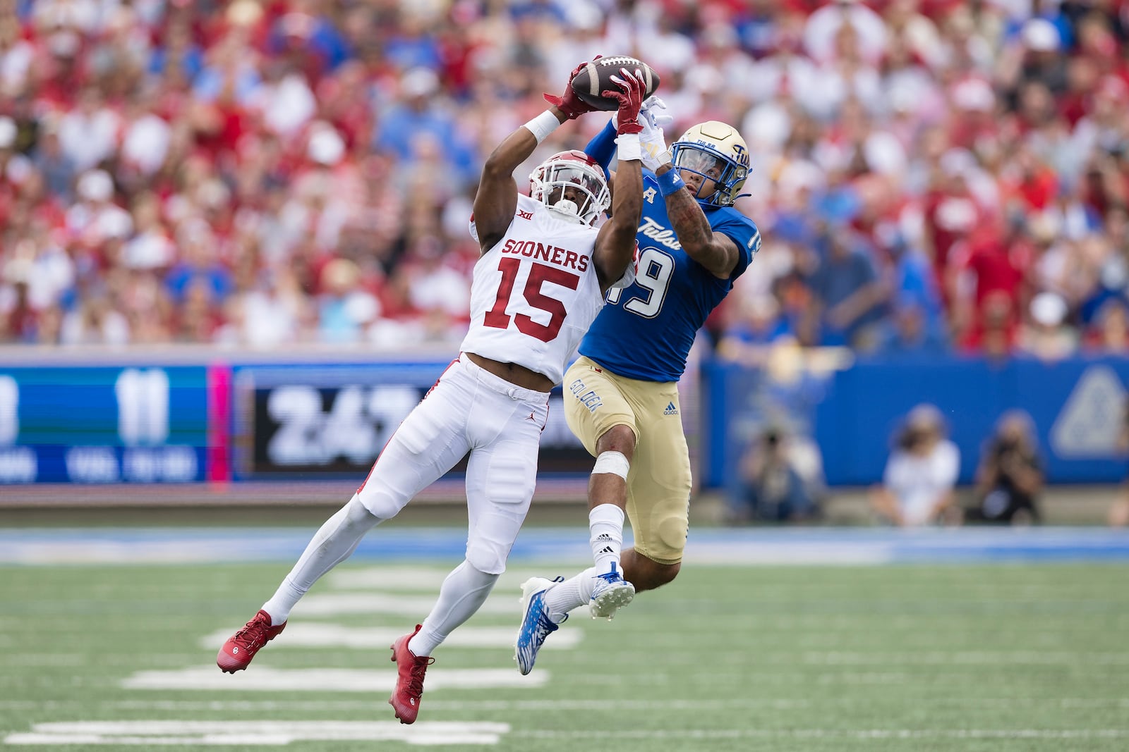 Oklahoma defensive back Kendel Dolby (15) intercepts a ball intended for Tulsa wide receiver Devan Williams (19) during the first half of an NCAA college football game Saturday, Sept. 16, 2023, in Tulsa, Okla. (AP Photo/Alonzo Adams)