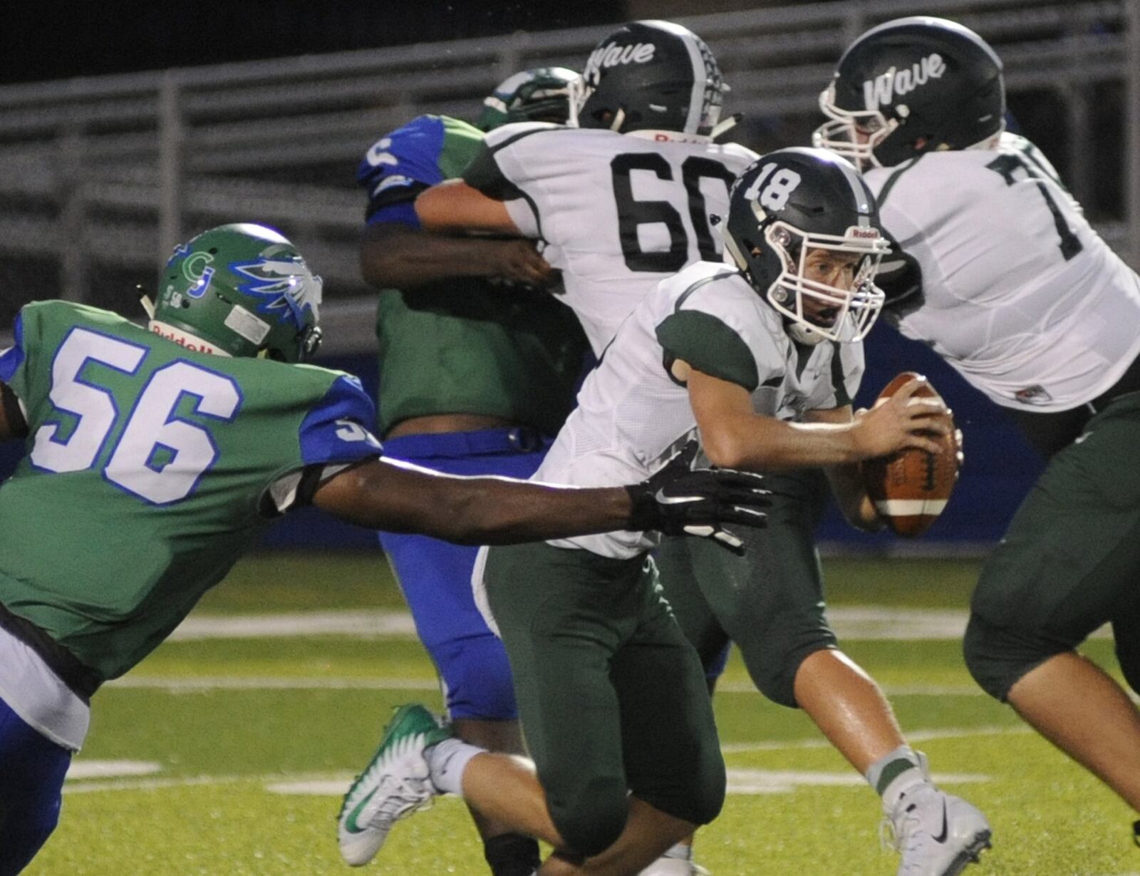 Chaminade Julienne’s Shane Cokes (56) takes down Greenville quarterback Tyler Beyke on Sept. 6 during CJ’s 58-16 victory at Roger Glass Stadium in Dayton. MARC PENDLETON/STAFF