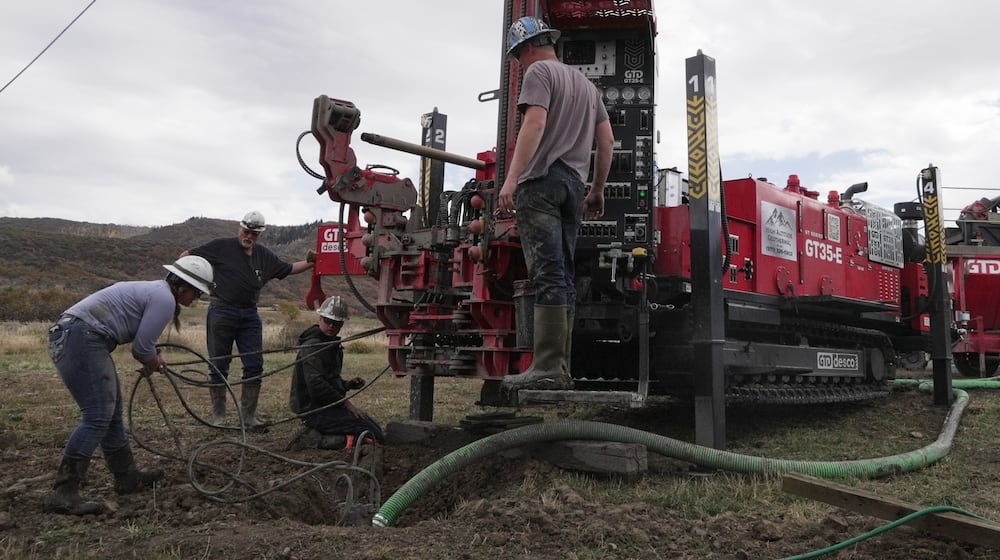 Matt Cooper and his kids Anna, Nathan and Matthew prepare to drill a hole for a geothermal heat pump installation Thursday, Oct. 9, 2025, in Hamilton, Colo. (AP PhotoBrittany Peterson)