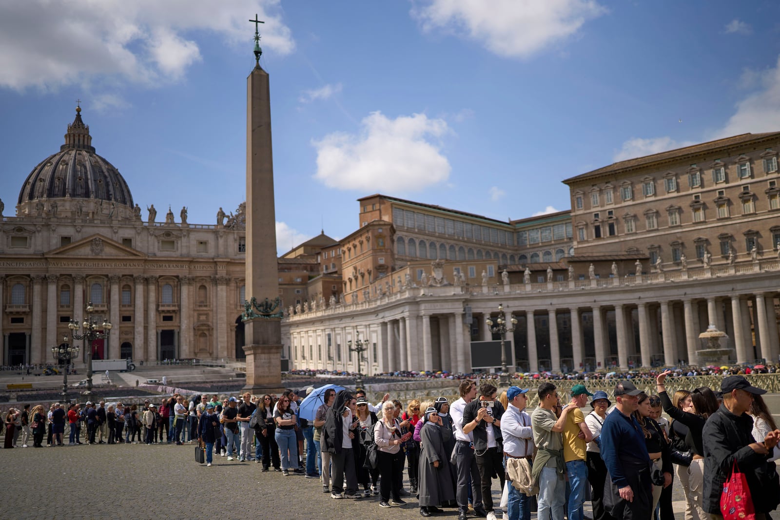 People queue in St. Peter's Square to pay their respect to the late Pope Francis, who will lie in state at St. Peter's Basilica for three days, at the Vatican, Wednesday, April 23, 2025. (AP Photo/Emilio Morenatti)
