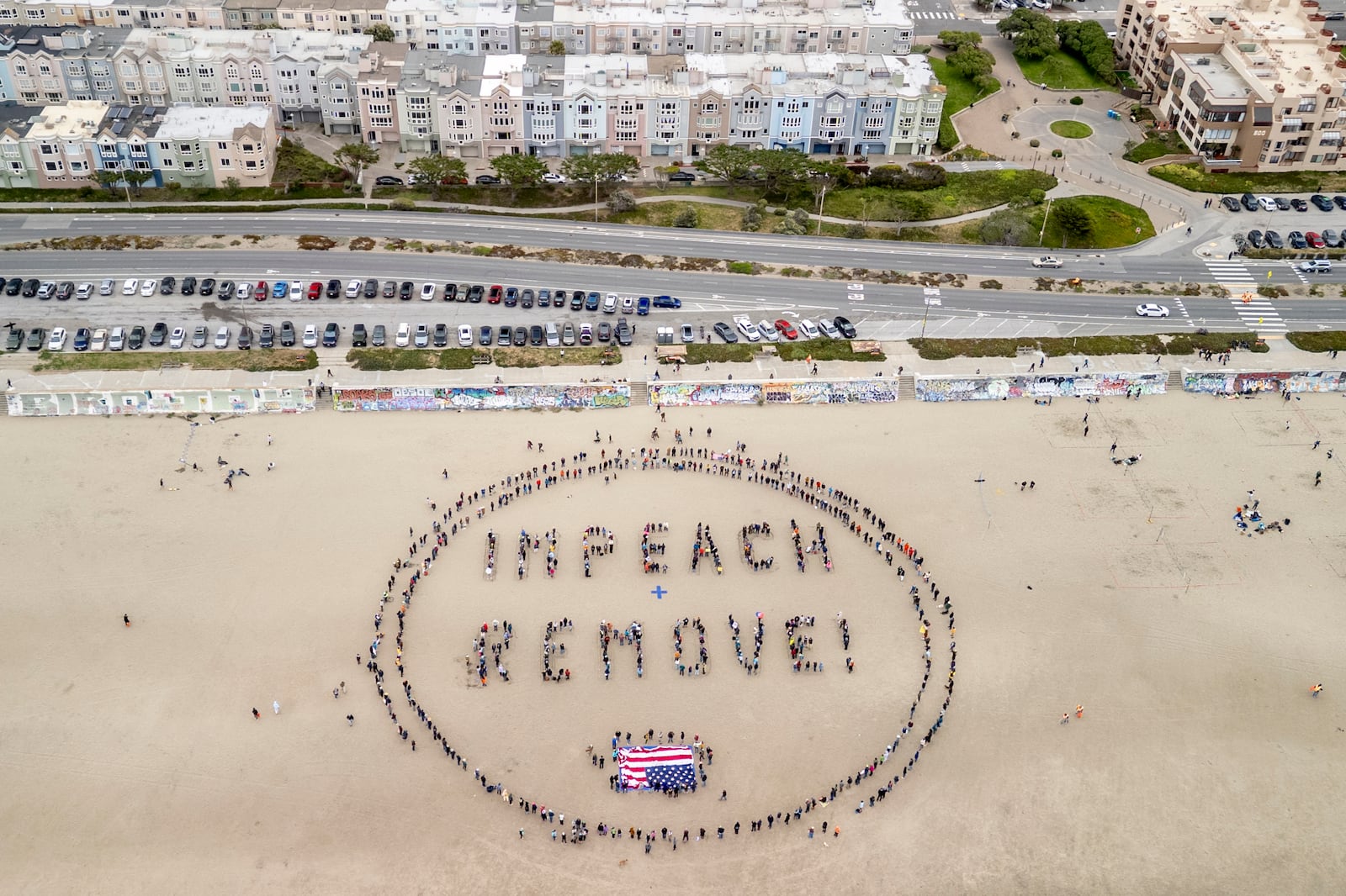 Protesters form a "Impeach & Remove" human banner on Ocean Beach during a protest against U.S. President Donald Trump, in San Francisco, Saturday, April 19, 2025. (Stephen Lam/San Francisco Chronicle via AP)