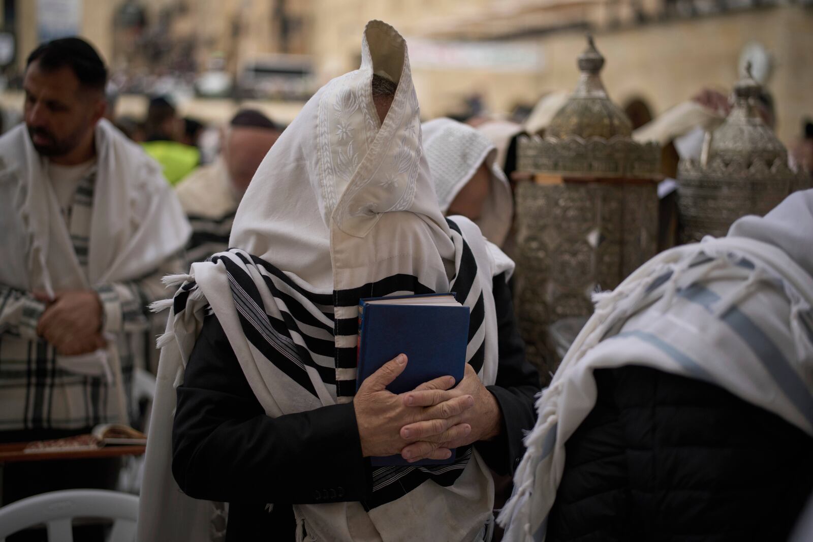 Covered in prayer shawls, a Jewish man of the Cohanim Priestly caste participates in a blessing during the holiday of Passover, at the Western Wall, the holiest site where Jews can pray, in the Old City of Jerusalem, Tuesday, April 15, 2025. (AP Photo/Leo Correa)