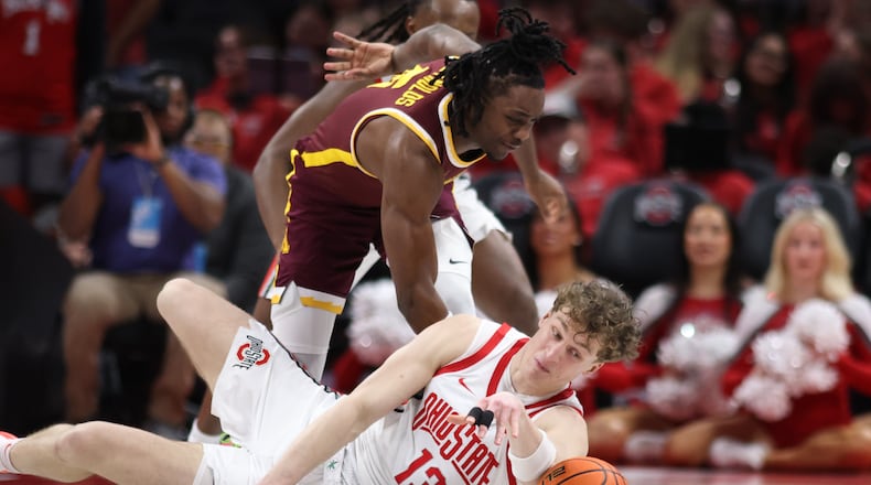Ohio State center Christoph Tilly, right, reaches for a loose ball in front of Minnesota guard Langston Reynolds during the second half of an NCAA college basketball game in Columbus, Ohio, Tuesday, Jan. 20, 2026. (AP Photo/Paul Vernon)