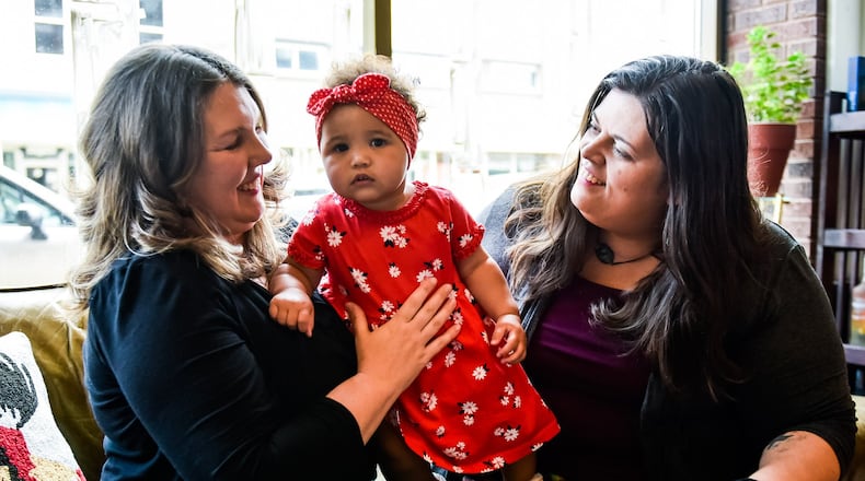 Diana Arnold, left, and Melissa Kutzera hold their daughter Leona, 1. Diana and Melissa have been married nearly five years and their adoption of Leona was final in April of this year. NICK GRAHAM / STAFF