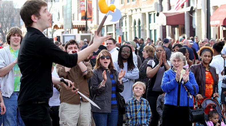 E.L. Hubbard photography People watch a street performer during the NCAA First Four Festival in downtown Dayton's Oregon District Sunday, March 11, 2012. Big Hoopla, a volunteer based non-profit that organizes local activities around the NCAA First Four and the Division I Men’s Basketball Tournament held at the University of Dayton, and the Oregon District Business Association will hold a family-friendly festival 10 a.m. to 8 p.m. March 15, 2020.