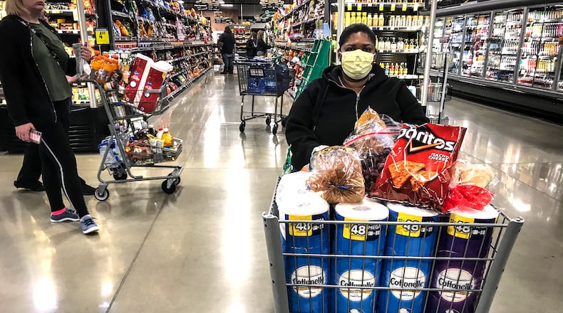 A shopper at the new Kroger Market Place on Alex Bell, waits in line to check out while shopping last month. JIM NOELKER/STAFF