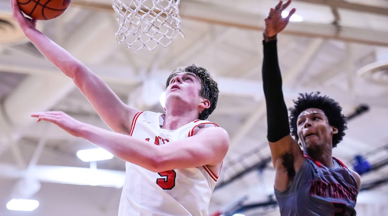 Madison’s Grant Whisman puts up a shot defended by Northridge’s Charles Drewery during Friday night’s game in Madison Township. Northridge won 58-56. NICK GRAHAM/STAFF