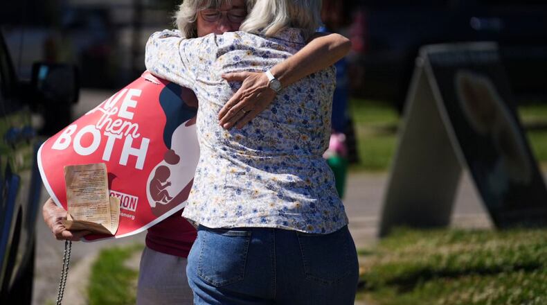 Mari Schoen hugs a fellow supporter as they celebrate the overturning of Roe v Wade by the Supreme Court while standing outside of the Planned Parenthood Clinic in Columbus, Ohio, on Friday, June 24, 2022. The Supreme Court has ended constitutional protections for abortion that had been in place nearly 50 years in a decision by its conservative majority to overturn Roe v. Wade. Friday's outcome is expected to lead to abortion bans in roughly half the states. (Courtney Hergesheimer/The Columbus Dispatch via AP)