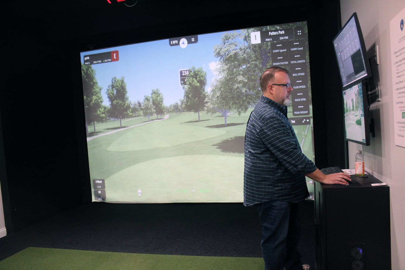 The Clubhouse Golf Suites owner Michael Kroeger selected Potter Park Golf Course in Hamilton to play on the simulator in one of the suites guests can rent. SUE KIESEWETTER/CONTRIBUTED