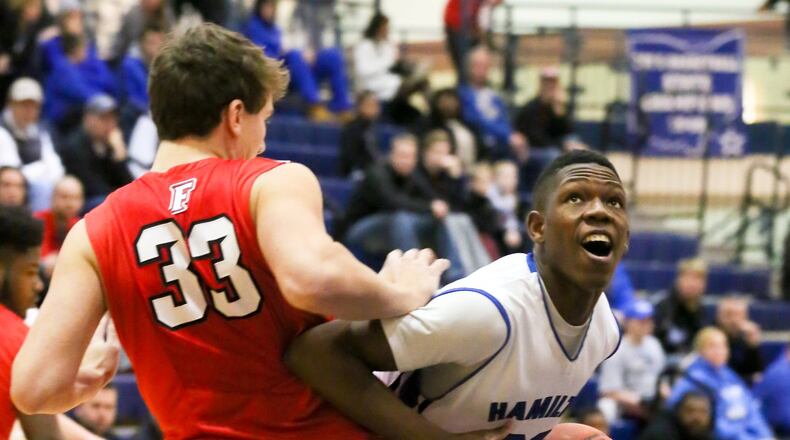 Hamilton forward Myles Howard (20) looks to the rim around Fairfield defender Aaron Carmack (33) during their game at the Hamilton Athletic Center on Feb. 9. GREG LYNCH/STAFF