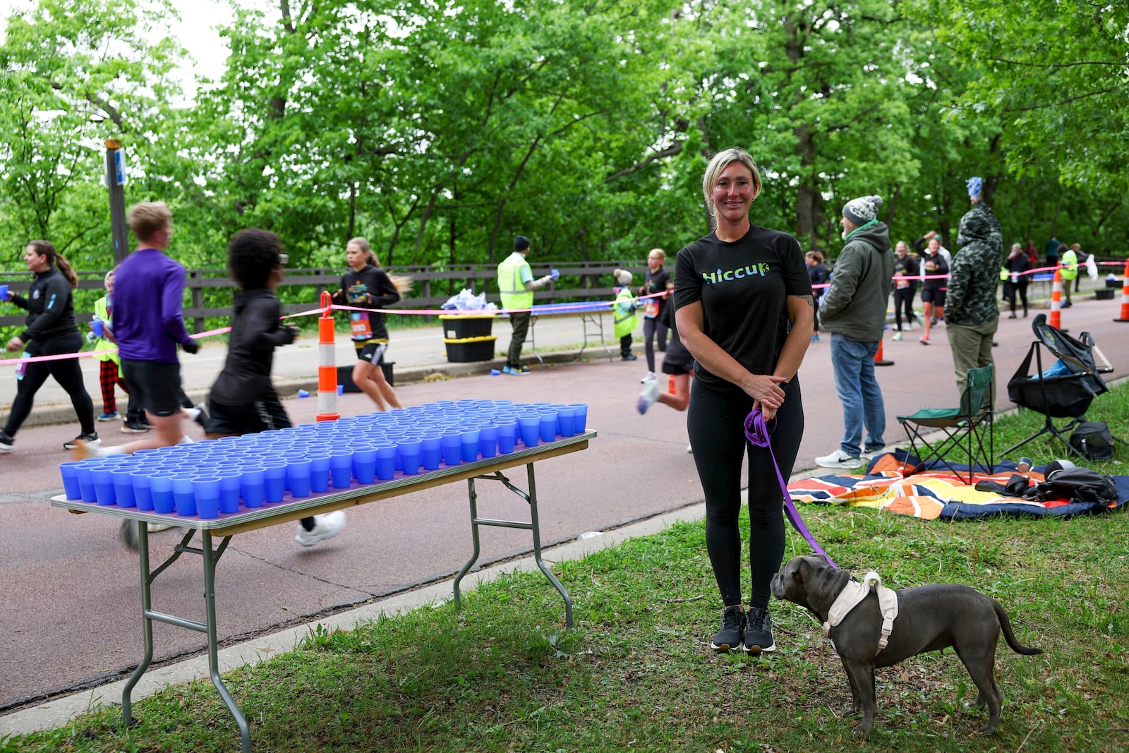 Kristina Smithe, founder of Hiccup, a reusable silicone cup, stands for a portrait with her rescue dog, Tina, during the PNC Women Run the Cities race on Saturday, May 17, 2025, in Minneapolis. (AP Photo/Ellen Schmidt)