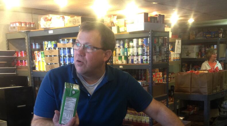 Fairfield Food Pantry worker Wayne Patten grabs a container of milk in February 2016 for a food pantry client. MICHAEL D. PITMAN/FILE