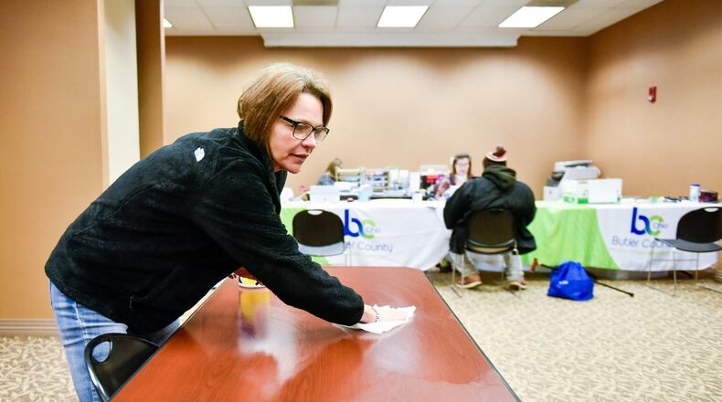 Janette Prater, a unit support worker with Butler County Job and Family Services, wipes tables with a disinfecting cloth between visitors Thursday. Butler County Job and Family Services and Child Support Enforcement Agency have set up a makeshift office in a conference room on the ground floor of the Government Services Center in Hamilton to help ease access for those in need of help during the coronavirus (COVID-19) outbreak. They are sanitizing tables, keyboards, telephones, pens and other items frequently to help minimize risk of spreading germs. NICK GRAHAM/STAFF