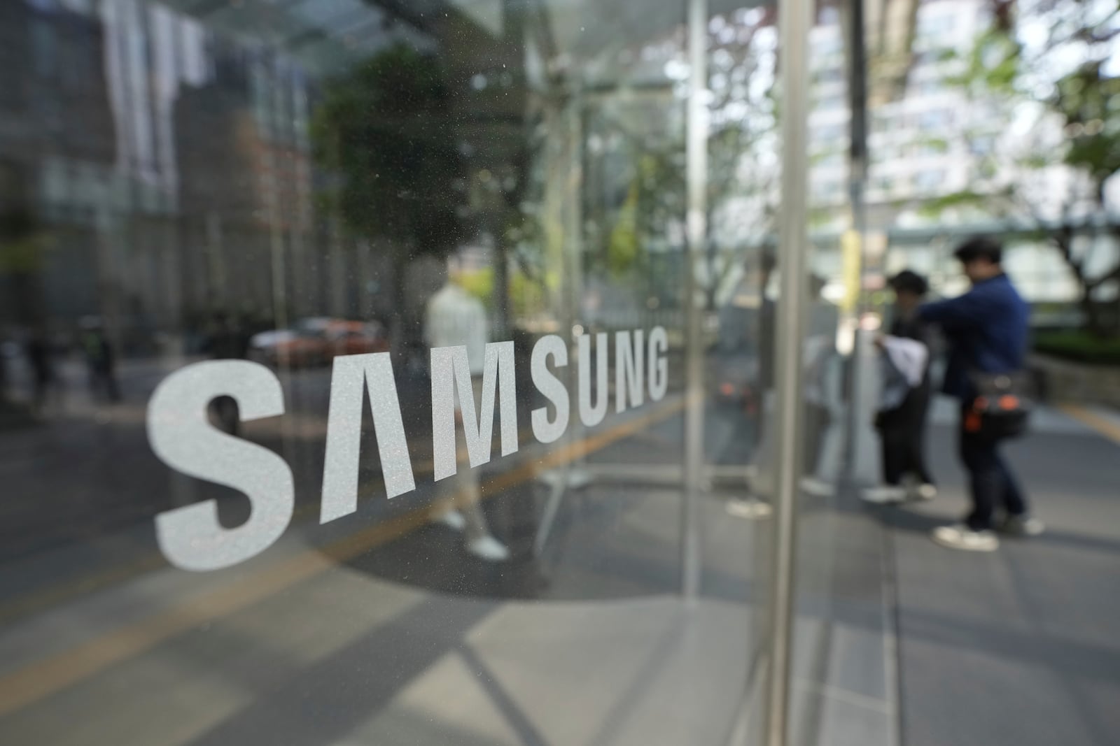 Employees walk past the logo of the Samsung Electronics Co. at its office in Seoul, South Korea, South Korea, Tuesday, April 29, 2025. (AP Photo/Ahn Young-joon)