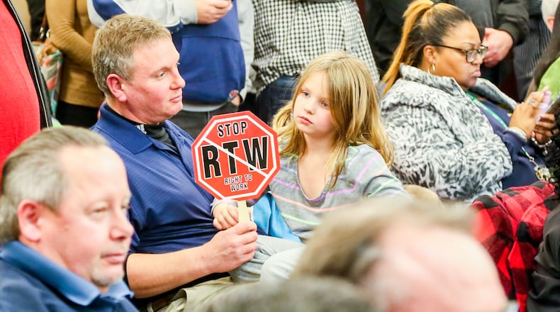 Peter McLinden, executive secretary-treasurer of Cincinnati AFL-CIO Labor Council, holds an sign protesting “right to work” during a January West Chester Twp. trustee meeting. An overflow crowd of union workers converged on the meeting to protest a plan to make the township a “right-to-work” community. GREG LYNCH/STAFF