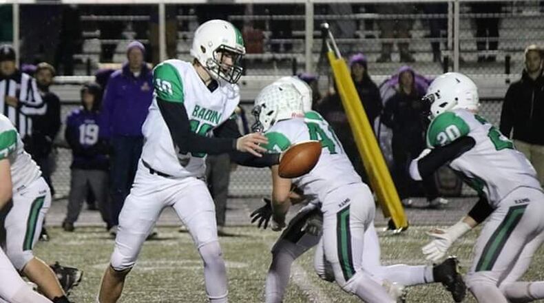 Badin quarterback Zach Switzer is about to hand off to Alex DeLong (20) as Ethan Wishart (41) provides some blocking in last Friday’s 33-22 victory over Vandalia Butler in a Division III, Region 12 playoff game at Memorial Field in Vandalia. CONTRIBUTED PHOTO BY TERRI ADAMS