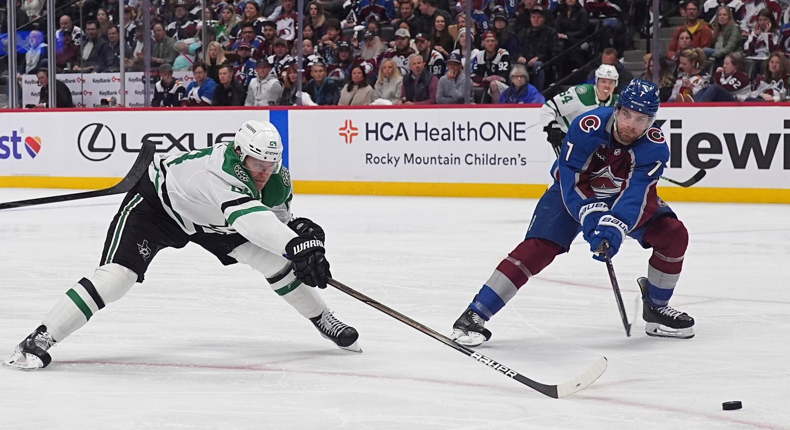 Dallas Stars center Roope Hintz, left, misses a pass as Colorado Avalanche defenseman Devon Toews covers in the second period of Game 3 of an NHL hockey first-round playoff series Wednesday, April 23, 2025, in Denver. (AP Photo/David Zalubowski)