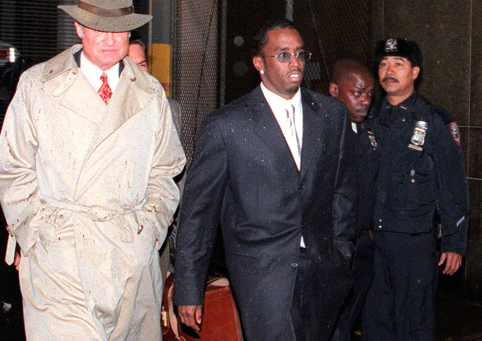 FILE - Rap artist and music producer Sean "Puffy" Combs, center, leaves a court hearing at New York's Manhattan Criminal Court on April 16, 1999, after Combs was charged with beating rap record executive, Steven Stoute, the previous day. (AP Photo/Robert Mecea, File)