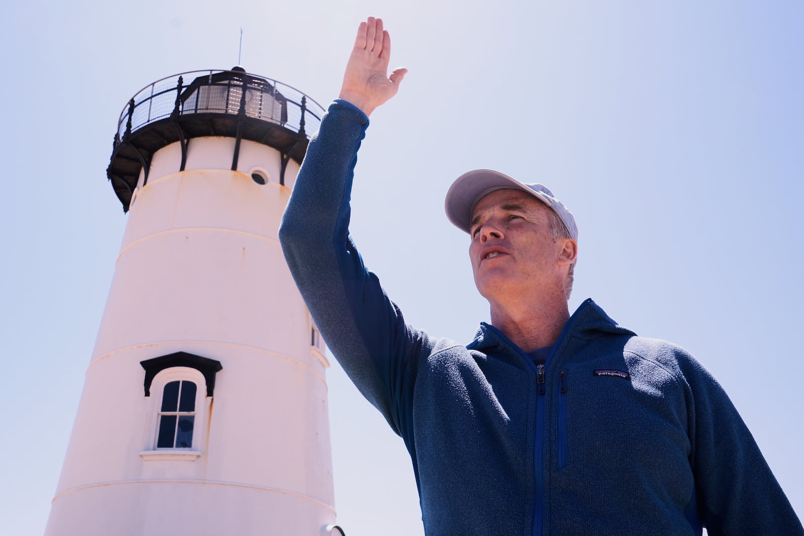 Endurance swimmer Lewis Pugh gestures to where he will begin his swim around Martha's Vineyard island, which is expected to take 12 days, near the Edgartown Lighthouse, Monday, May 12, 2025, in Edgartown, Mass. (AP Photo/Charles Krupa)