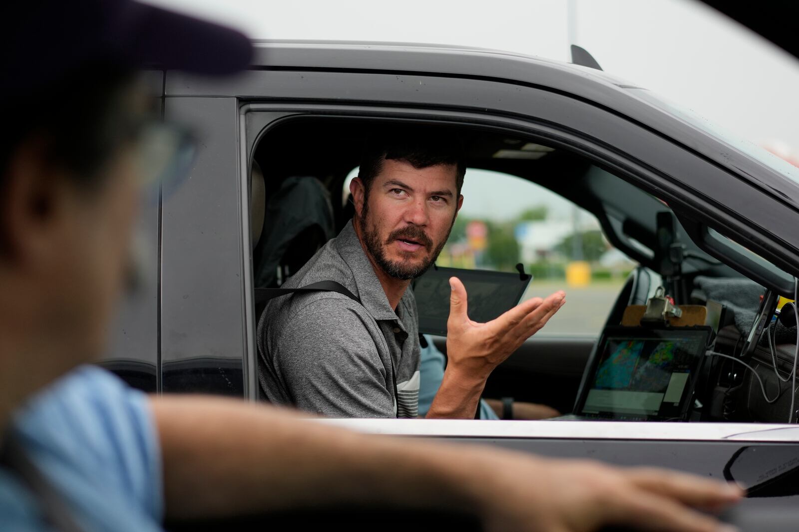 Victor Gensini, Northern Illinois University meteorology professor and a lead scientist of Project ICECHIP, speaks with Seth Borenstein, Associated Press science writer, as they stage in a Walmart parking lot before a Project ICECHIP operation Tuesday, June 3, 2025, in Atlus, Okla. (AP Photo/Carolyn Kaster)