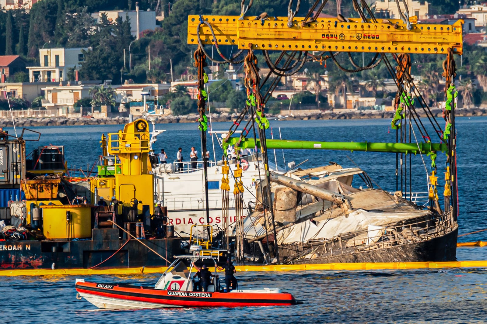 The hull of the superyacht Bayesian, which sank near Palermo, Sicily, on August 19, 2024, is lifted by cranes during salvage operations off the village of Porticciolo Saturday, June 21, 2025. (AP Photo/Salvatore Cavalli)