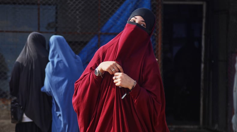 Women wait to enter a building supplying food and other goods at Roj camp, one of the detention facilities holding thousands of Islamic State group members and their families, in the al-Malikiyah area of northeastern Syria, Thursday, Jan. 29, 2026. (AP Photo/Baderkhan Ahmad)