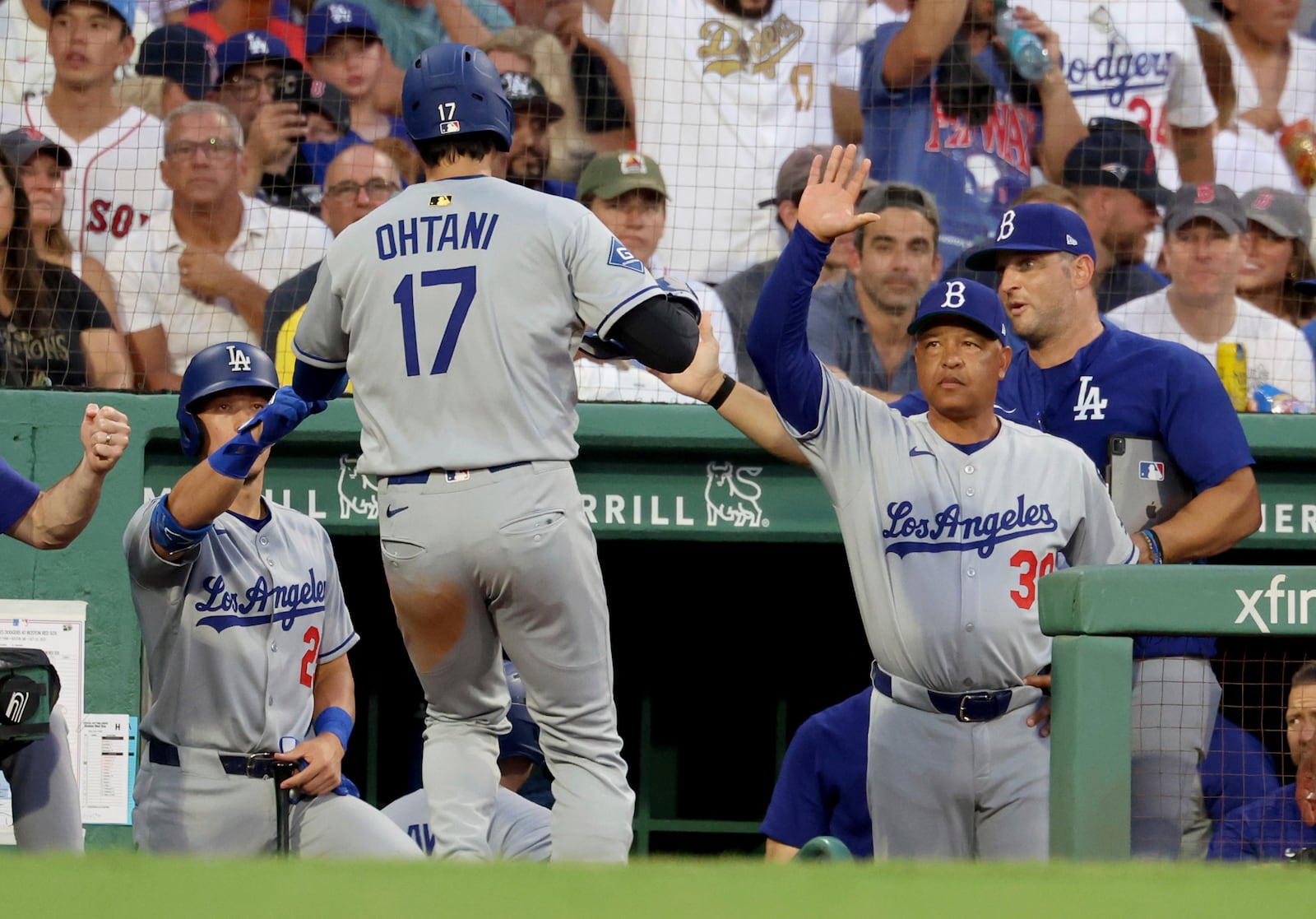 Los Angeles Dodgers designated hitter Shohei Ohtani (17) celebrates his run with a high five to manager Dave Roberts, right, during the third inning of a baseball game against the Boston Red Sox, Friday, July 25, 2025, in Boston. (AP Photo/Mark Stockwell)