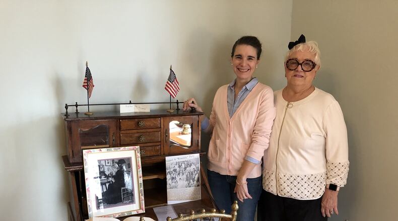 Carrie Halim, left, and Kathleen Stuckey Fox stand next to a desk once used by early-20th century Journal-News columnist Stella Weiler Taylor, whose photograph as an older woman sits on the desk. They are in a new history room at The Father’s House, which is on the D Street property of the former Butler County Children’s Home. MIKE RUTLEDGE/STAFF
