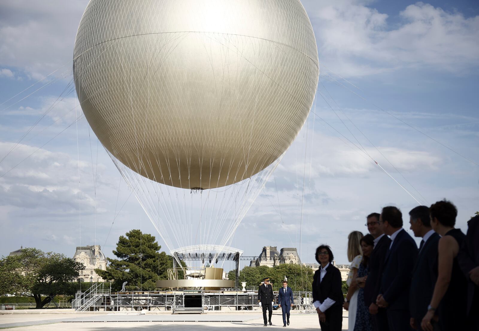 French President Emmanuel Macron, right background, visits the site of the reinstallation of the Olympic cauldron at the Tuileries Garden in Paris, Thursday, June 12, 2025. (Yoan Valat/Pool Photo via AP)