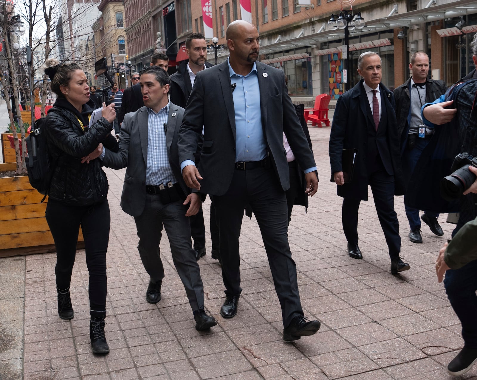 Security keeps a person from the right-wing media group Rebel News away from Prime Minister Mark Carney as he walks to a news conference, in Ottawa, Friday, May 2, 2025. (Adrian Wyld/The Canadian Press via AP)