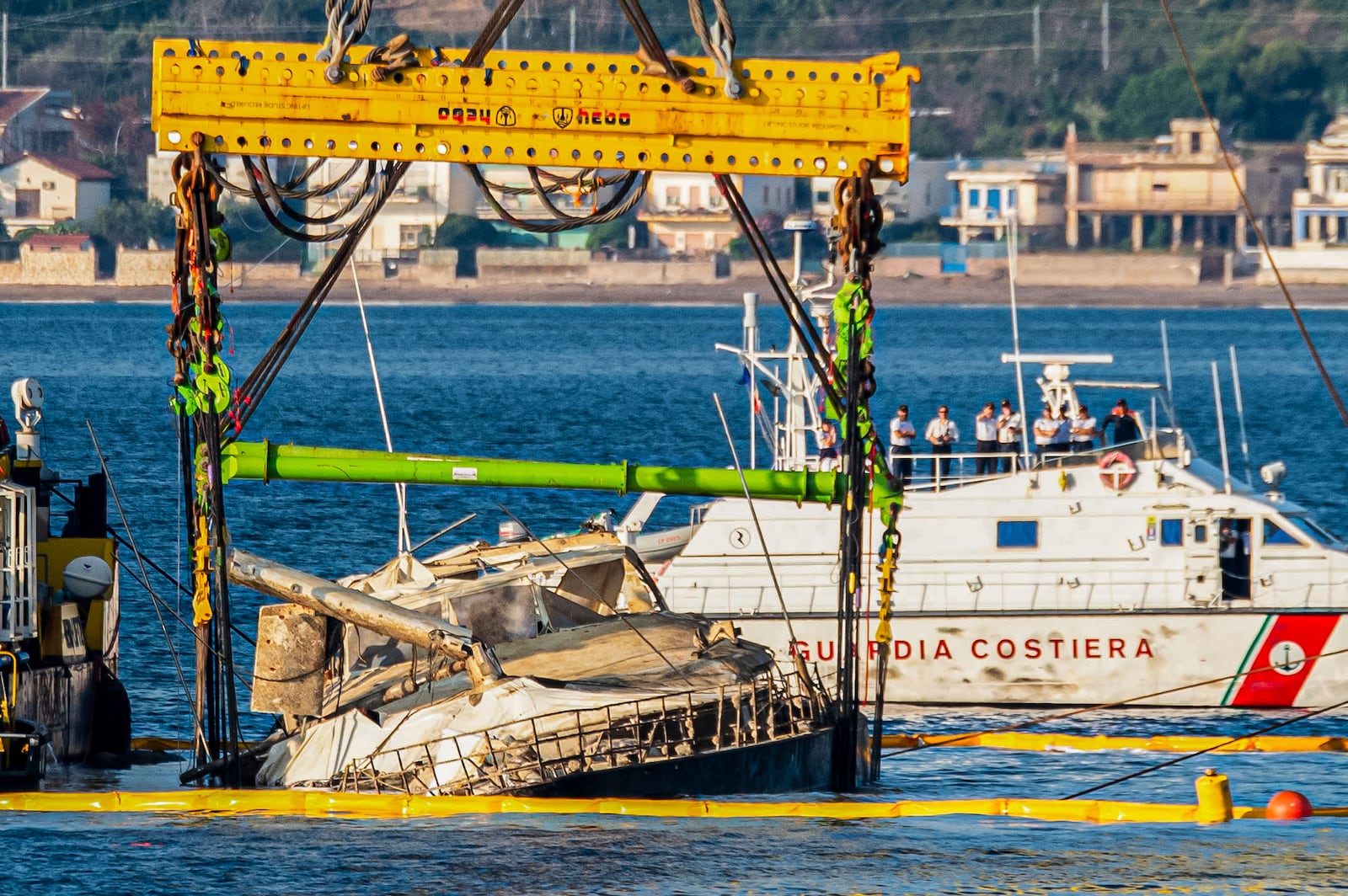 The hull of the superyacht Bayesian, which sank near Palermo, Sicily, on August 19, 2024, is lifted by cranes during salvage operations off the village of Porticciolo Saturday, June 21, 2025. (AP Photo/Salvatore Cavalli)