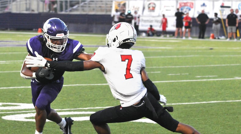 Middletown's Eric Schroeder, 3, attempts to get past Colerain's Lawrence Young, 7, during the second quarter of a Greater Miami Conference game at Middletown's Barnitz Stadium on Friday, Aug. 25. DAVID A. MOODIE/CONTRIBUTING PHOTOGRAPHER