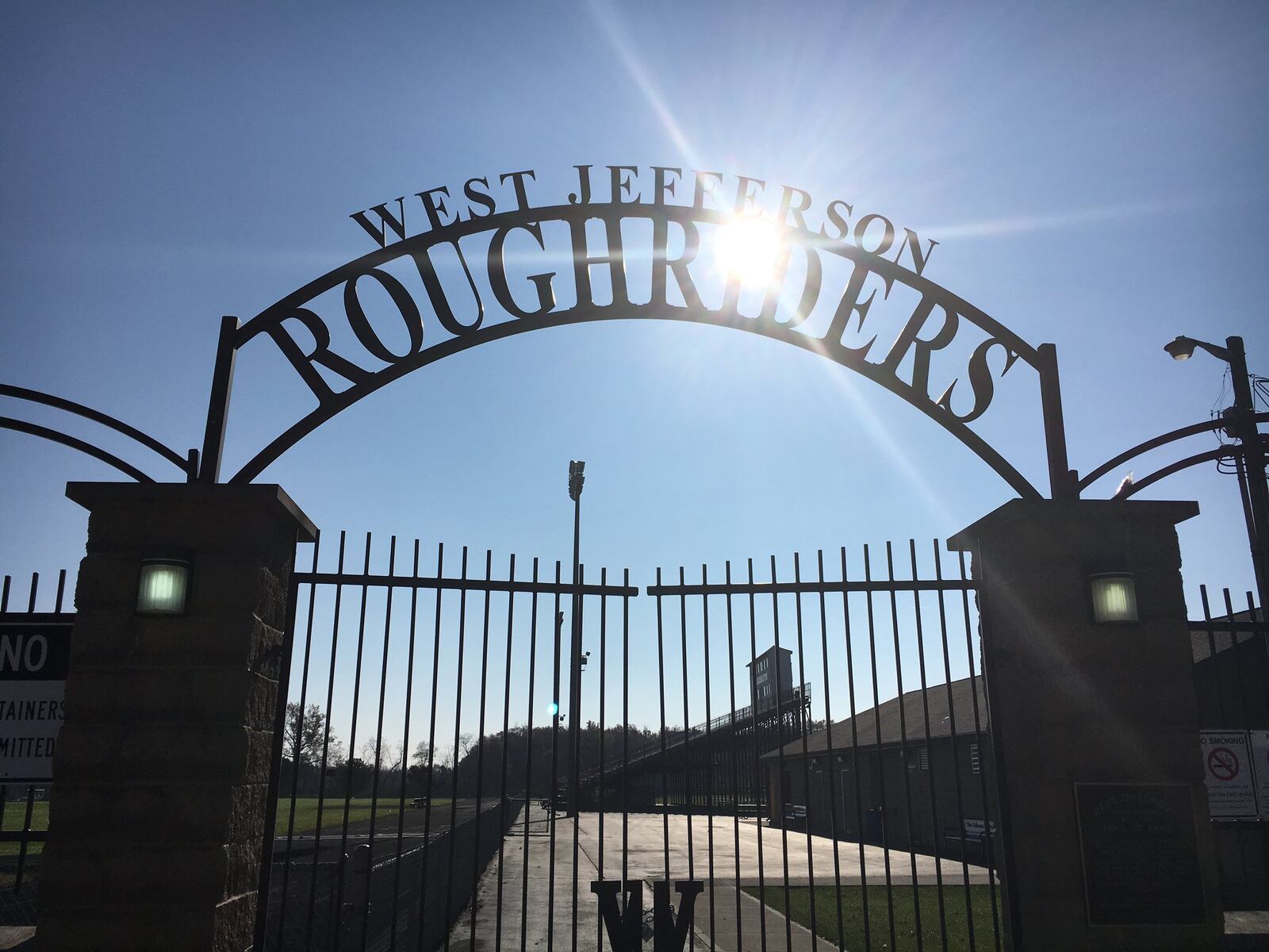 The sun shines through the front gate of West Jefferson High School’s Kile Stadium this week in Madison County. RICK CASSANO/STAFF