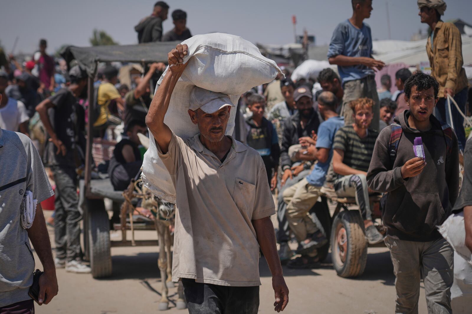 Palestinians carry food and humanitarian aid packages delivered by the Gaza Humanitarian Foundation, a U.S.-backed organization, in Rafah, southern Gaza Strip, Thursday, June 26, 2025. (AP Photo/Abdel Kareem Hana)