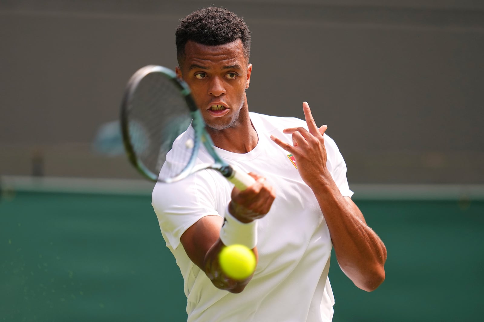Giovanni Mpetshi Perricard of France returns the ball to Taylor Fritz of the U.S. during their first round men's singles match at the Wimbledon Tennis Championships in London, Tuesday, July 1, 2025.(AP Photo/Kirsty Wigglesworth)