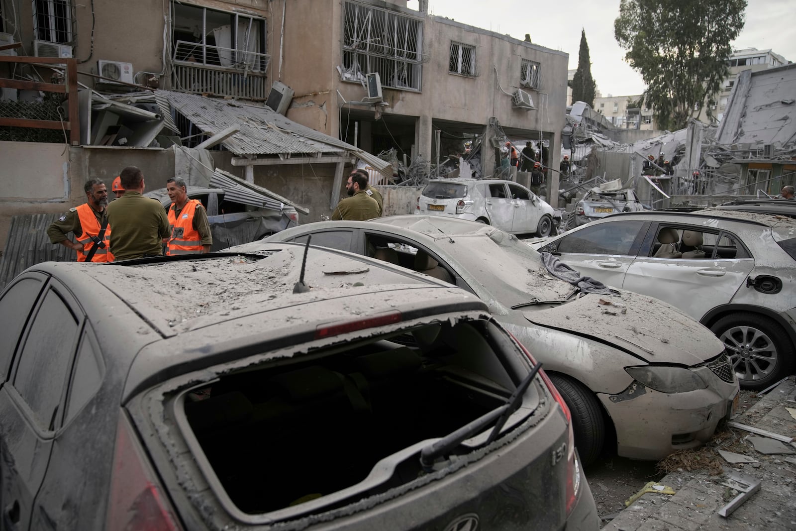 Damaged cars are seen at the site where an Iranian missile struck in Bnei Brak, near Tel Aviv, Israel, Monday, June 16, 2025. (AP Photo/Leo Correa)