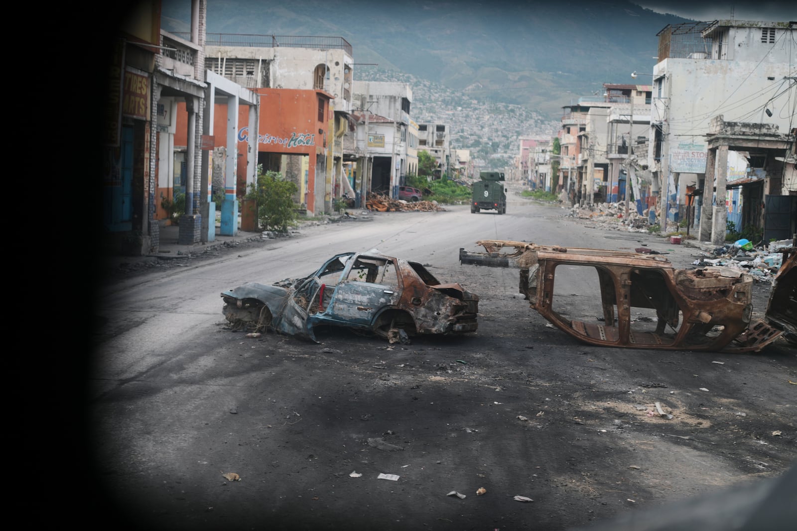 Burned cars block a street, photographed from inside an armored police vehicle patrolling a gang-controlled area in Port-au-Prince, Haiti, Friday, Jan. 16, 2026. (AP Photo/Odelyn Joseph)